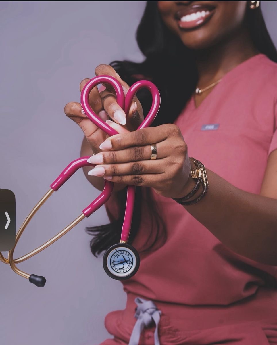 Nurse holding pink heart-shaped stethoscope — Vitalz n Vibez heart of the brand