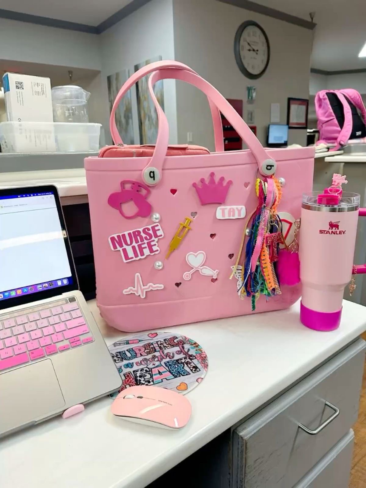 Pink nurse desk setup with Nurse Life bag and Stanley cup — Vitalz n Vibez wellness brand aesthetic
